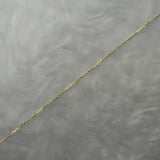 0.68mm super fine and delicate diamond-cut cable chain necklace for charms or pendants. The chain is against a grey background with swirling patterns.