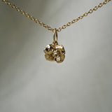 A solid gold hand-carved lily pad charm with brilliant and rose cut diamond dew, hanging from a 1mm cable chain with smooth oval links. Handmade in Toronto by Laurie Fleming Jewellery.