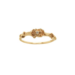 A stock photo of the solid gold "Pansy Signet" ring by Laurie Fleming Jewellery. The ring features hand-carved delicate petals encircling the band, with a tiny pansy flower at the centre, which has a customizable centre stone (pictured with a diamond, available in all birthstones). The ring is on a white background.