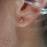 A close up of an ear wearing a Selene Stud earring by Laurie Fleming Jewellery, which features a rose cut diamond held in three delicate claw-shaped prongs.