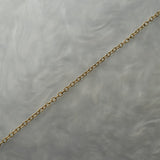 1.4mm cable chain with smooth oval links in solid 14k gold, perfect for wearing on its own or with charms or pendants. The chain is against a grey background with swirling patterns.