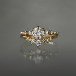 A Cyndra Ring, Supreme with a 0.50-0.55ct lab grown diamond centre on a 14k yellow gold band. The band features a combination of rose cut and brilliant cut diamond accents. The ring is stacked on top of a Brilliant Diamond Beacen Ring, both by Laurie Fleming Jewellery.
