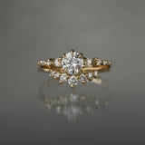 A Cyndra Ring, Supreme with a 0.50-0.55ct lab grown diamond centre on a 14k yellow gold band. The band features a combination of rose cut and brilliant cut diamond accents. The ring is stacked on top of a Brilliant Diamond Beacen Ring, both by Laurie Fleming Jewellery.