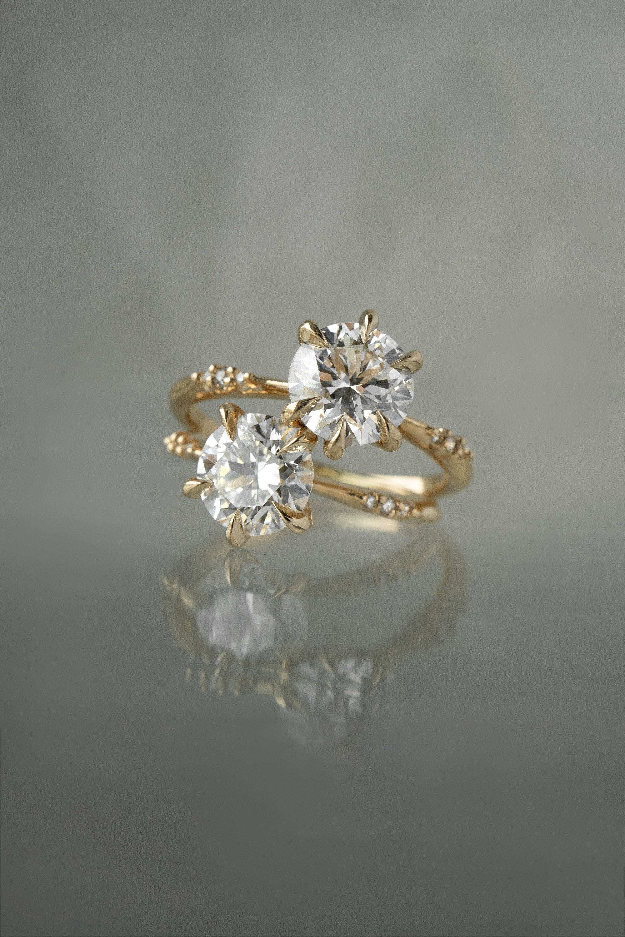 Two Brilliant Ilona Rings against a grey background by Laurie Fleming Jewellery