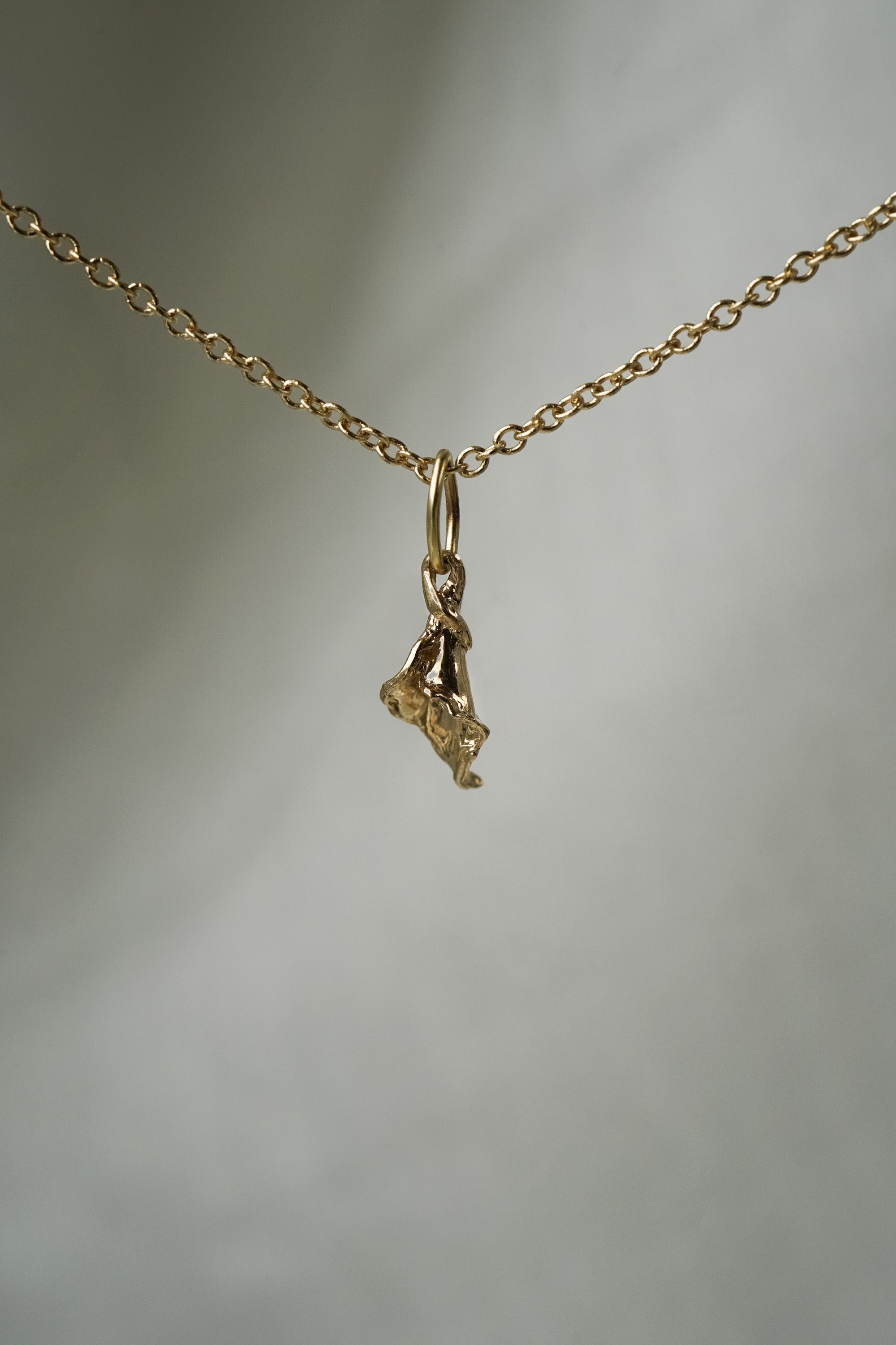 A delicate and dainty hand-carved calla lily flower blossom charm,  hanging from a 1mm cable chain with smooth oval links. Handmade in Toronto by Laurie Fleming Jewellery.