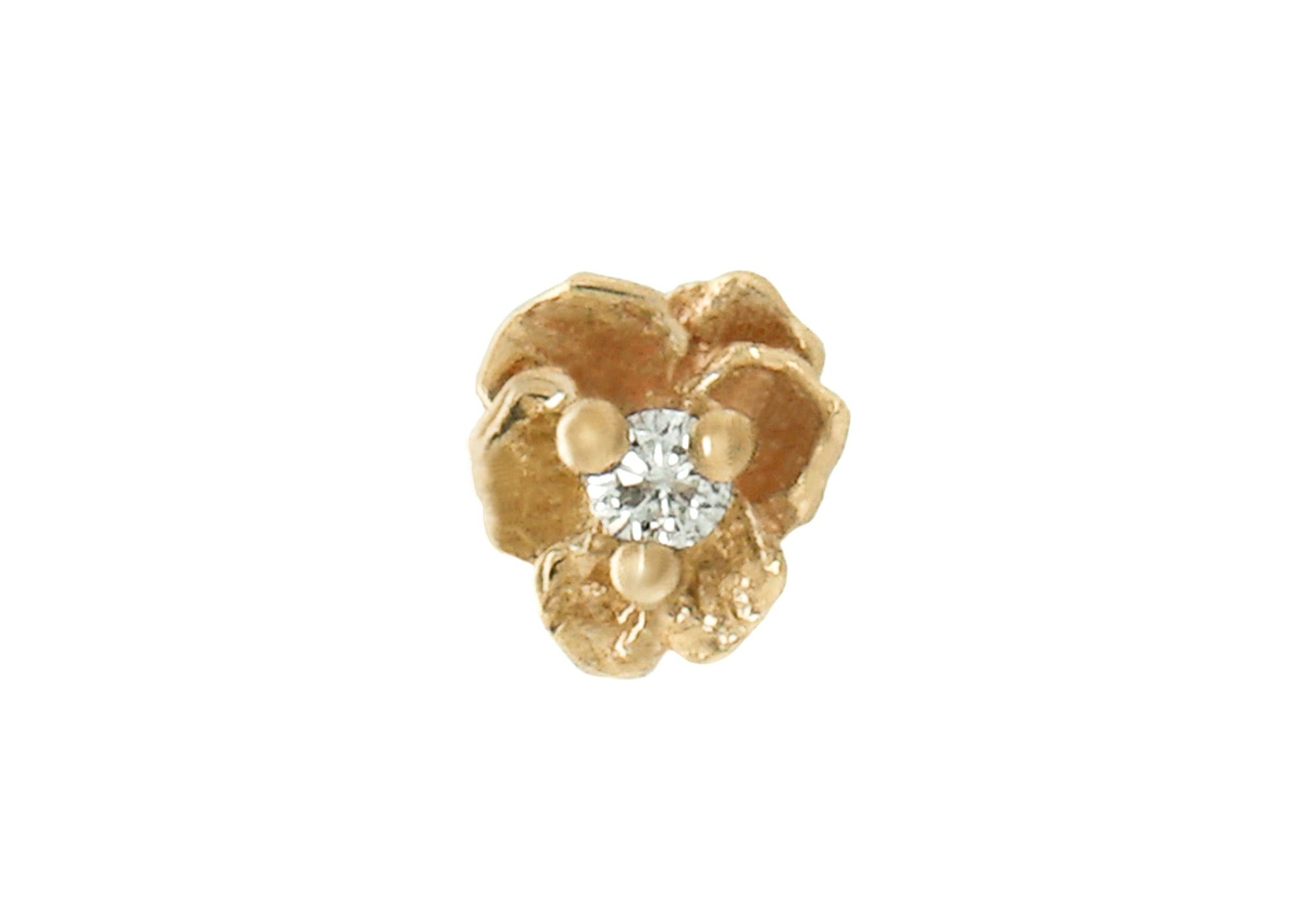 A product photo of a Pansy stud by Laurie Fleming Jewellery. It features a hand-carved miniature Pansy flower in solid 14k gold with a round brilliant cut diamond centre. The diamond can be swapped out for any birthstone.