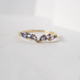 The Tanzanite Jasmine Ring featuring marquise cut tanzanites on the handcarved solid gold band. The ring is against a white background.