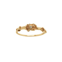 A stock photo of the solid gold "Pansy Signet" ring by Laurie Fleming Jewellery. The ring features hand-carved delicate petals encircling the band, with a tiny pansy flower at the centre, which has a customizable centre stone (pictured with a diamond, available in all birthstones). The ring is on a white background.