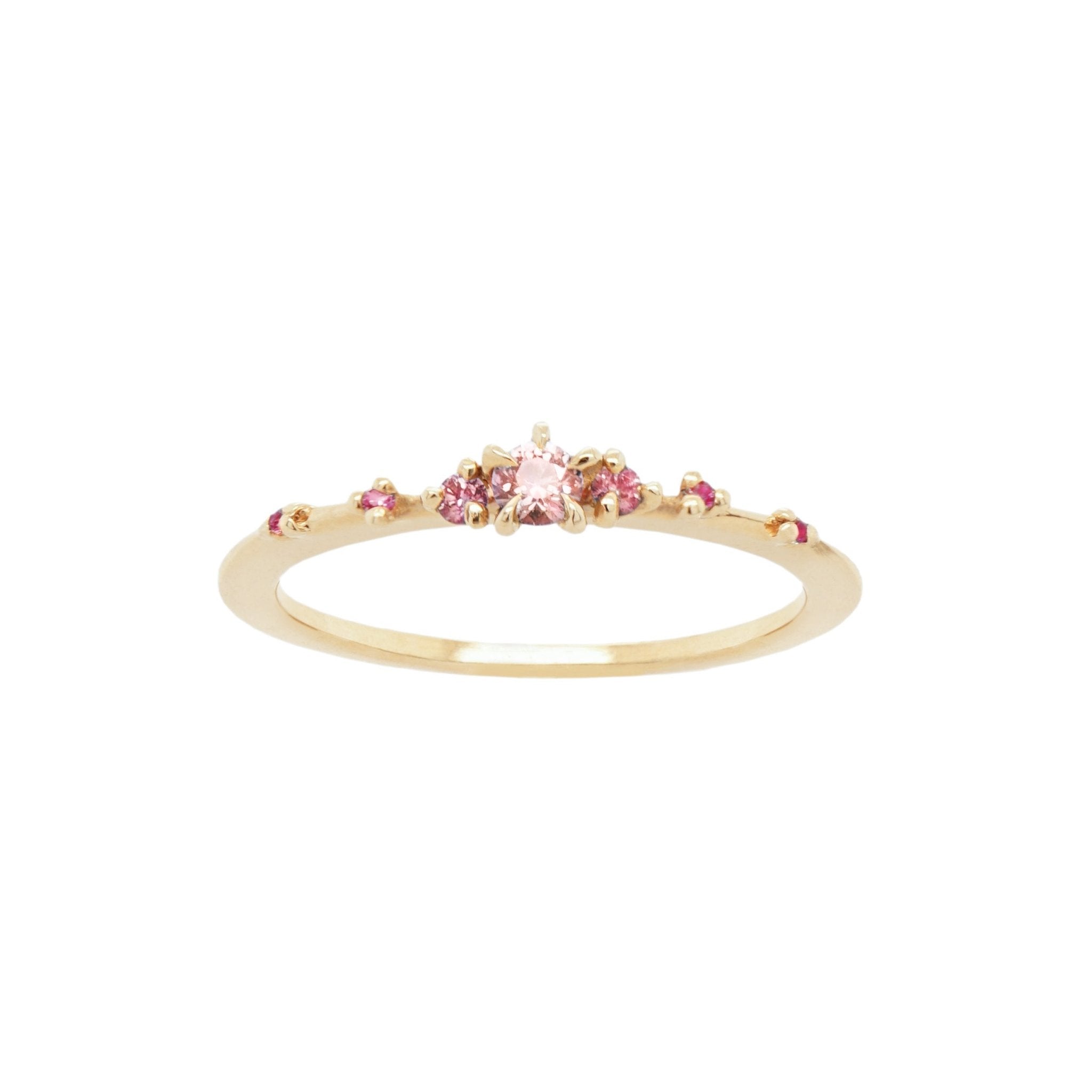 Laurie Fleming Jewellery's "Pink Sapphire Gradient Water Lily Ring," a delicate solid gold stacking ring with pink gradient sapphires scattered along the band. The ring is on a white background.