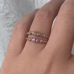 A hand wearing a rose cut diamond Cyndra Ring and a Pink Sapphire Cyndra Ring by Laurie Fleming Jewellery