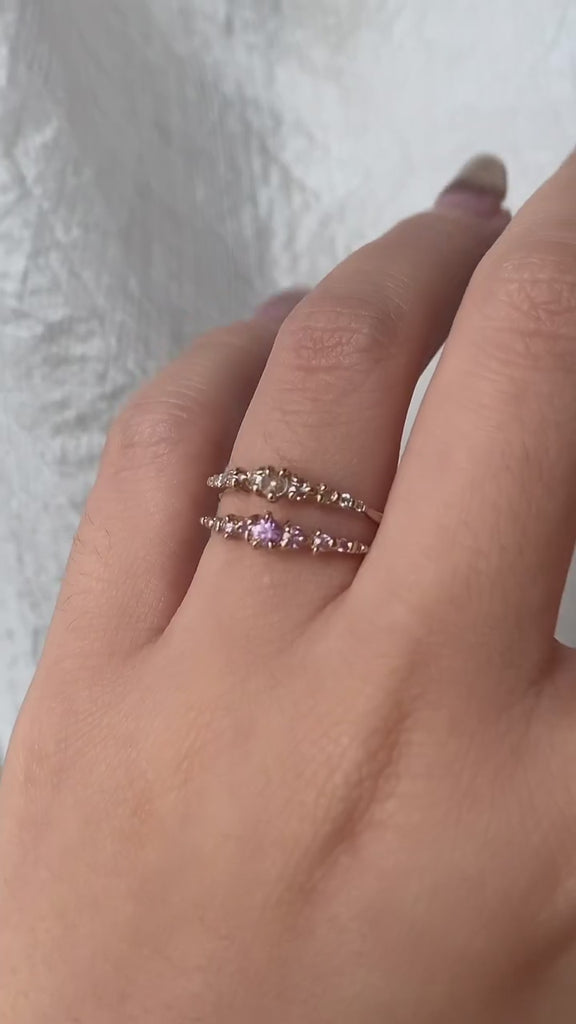 A hand wearing a rose cut diamond Cyndra Ring and a Pink Sapphire Cyndra Ring by Laurie Fleming Jewellery