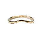 A stock photo of the Undine Band Ring by Laurie Fleming Jewellery. The ring is a handcarved solid gold contour ring with a gently tapered curve to stack well with most engagement rings. The ring is on a white background.