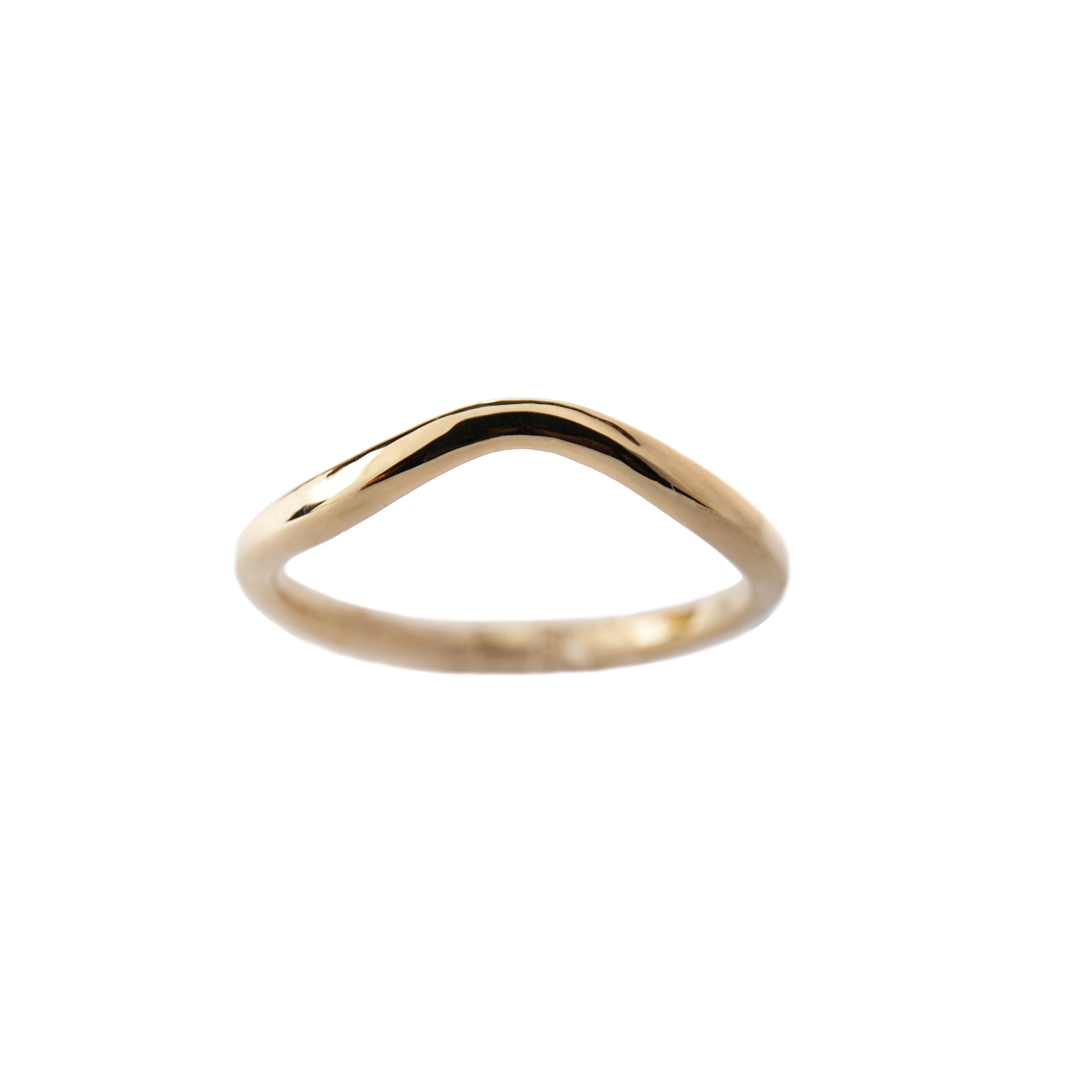 A stock photo of the Undine Band Ring by Laurie Fleming Jewellery. The ring is a handcarved solid gold contour ring with a gently tapered curve to stack well with most engagement rings. The ring is on a white background.