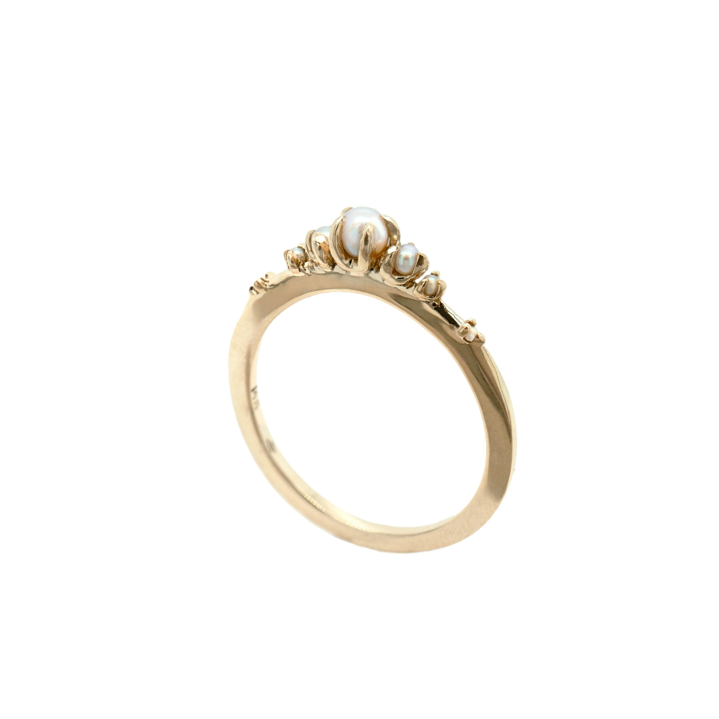 A product photo of Laurie Fleming Jewellery's "Pearl Water Lily Ring," a delicate solid gold stacking ring with freshwater seed pearls scattered along the band. The ring is on a white background.