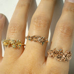 Three Asrai Garden Rings worn on one hand, including elements such as moss, magnolia branch, anemone, peonies, etc - Laurie Fleming Jewellery